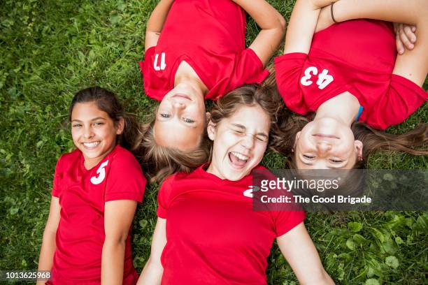 high angle view of female soccer players lying on ground - happy tween girls lying on grass stock pictures, royalty-free photos & images