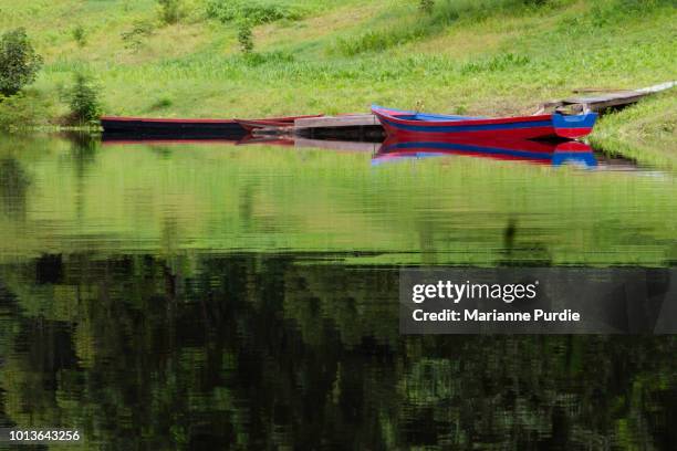 three brightly coloured canoes on the banks of the rio negro - rio amazonas stock pictures, royalty-free photos & images