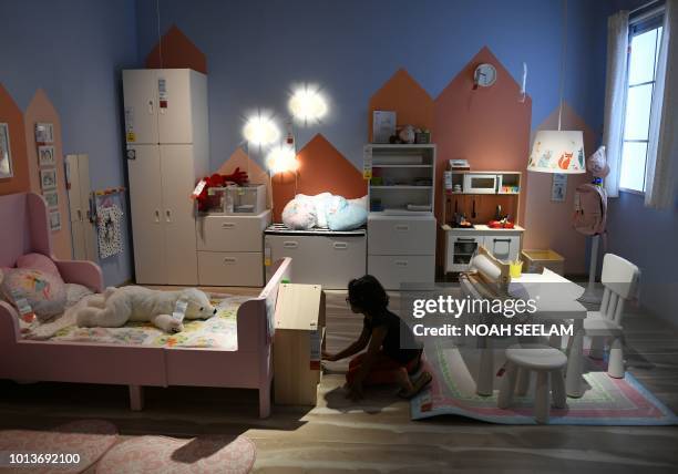 An Indian girl checks furnitures at the new IKEA store in Hyderabad on August 9, 2018. - Curious customers lay on beds and nestled into armchairs on...