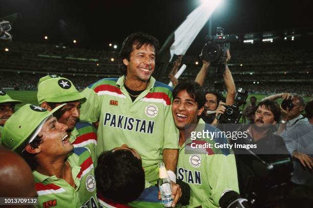 Pakistan captain Imran Khan celebrates with team mates as photographer David Munden looks on after the 1992 Cricket World Cup Final victory against...