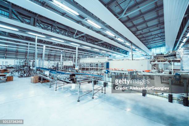 cadena de producción usada a botella y transportar agua en planta - manufacturing machinery fotografías e imágenes de stock