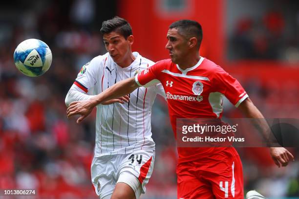 Angel Zaldivar of Chivas struggles for the ball with Osvaldo Gonzalez of Toluca during the third round match between Toluca and Chivas as part of the...