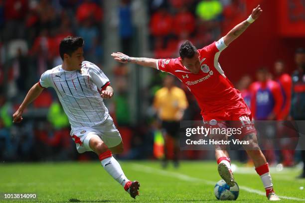 Michael Perez of Chivas struggles for the ball with Rubens Sambueza of Toluca during the third round match between Toluca and Chivas as part of the...