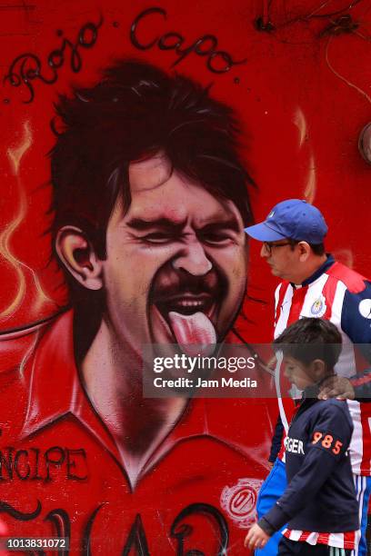 Fans look at a graffiti of Jose Saturnino Cardozo outside the stadium prior the third round match between Toluca and Chivas as part of the Torneo...