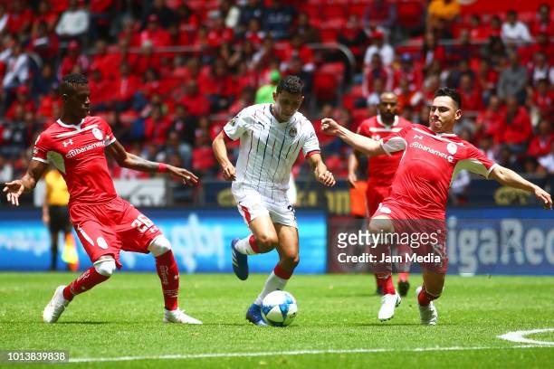 Orbelin Pineda of Chivas, Cristian Borja and Antonio Rios of Toluca fight for the ball during the third round match between Toluca and Chivas as part...