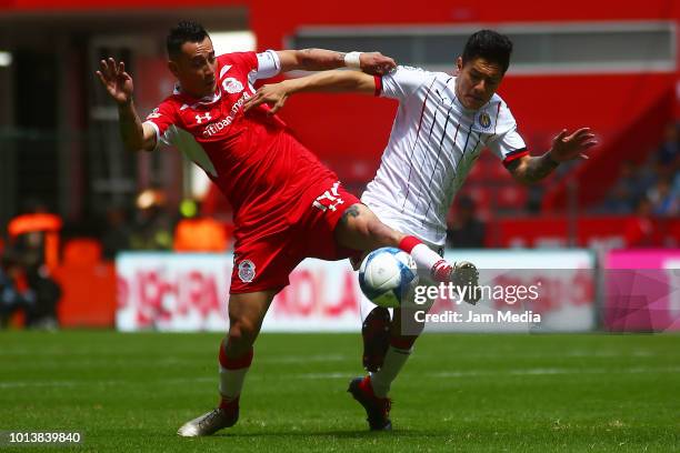 Rubens Sambueza of Toluca and Oswaldo Alanis of Chivas fight for the ball during the third round match between Toluca and Chivas as part of the...