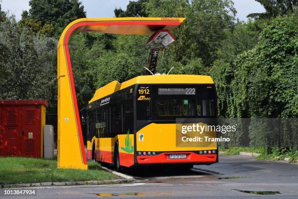 modern electric bus on the charging station - warsaw bus stock pictures, royalty-free photos & images