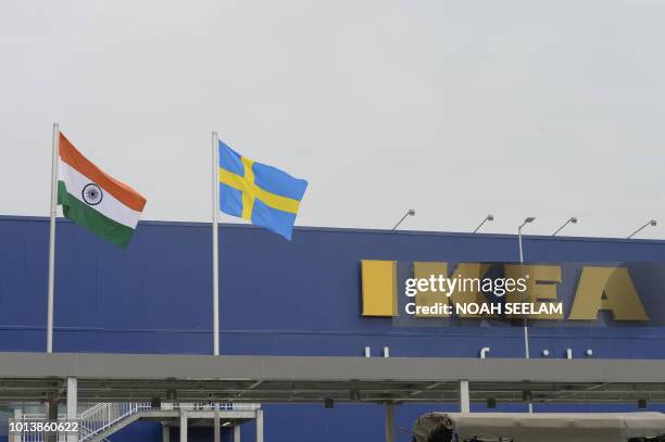 Indian National flag and Swedish flag are pictured at the new IKEA store in Hyderabad on August 9, 2018. - Curious customers lay on beds and nestled...