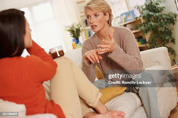 two women 30s 40s at home talking - two women talking stockfoto's en -beelden