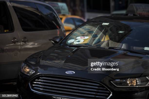 Lyft Inc. And Uber Technologies Inc. Logos are seen on the windshield of a vehicle in New York, U.S., on Thursday, Aug. 9, 2018. New York's city...