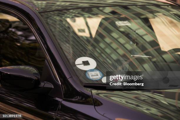 Lyft Inc. And Uber Technologies Inc. Logos are seen on the windshield of a vehicle in New York, U.S., on Thursday, Aug. 9, 2018. New York's city...