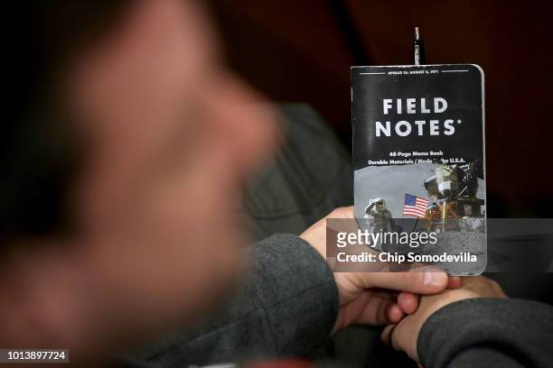 An attendee holds a space-themed notebook before a speech by U.S. Vice President Mike Pence to announce the Trump Administration's plan to create the...
