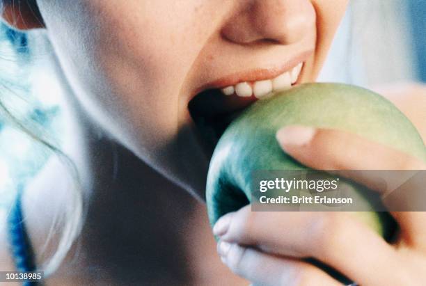 close up of woman eating an apple - mordere foto e immagini stock