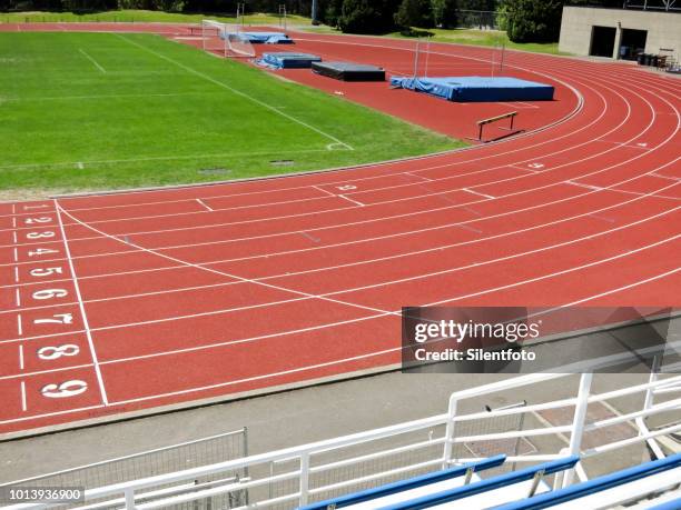 sweeping curve of red asphalt running track within stadium - track and field 個照片及圖片檔