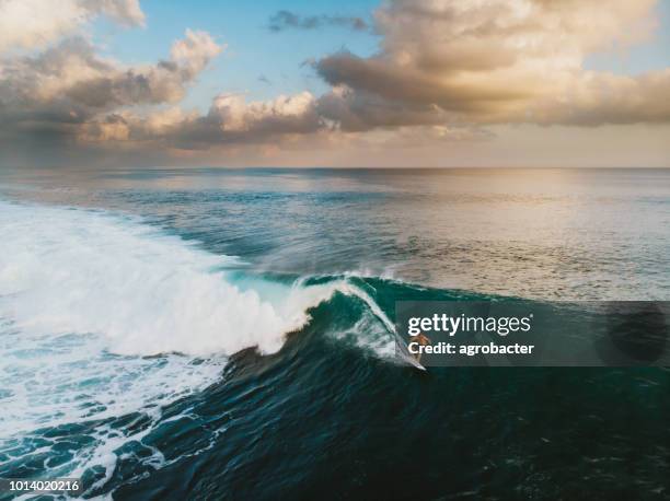 bali surf zone surfer riding a wave - longboard surfing stock pictures, royalty-free photos & images