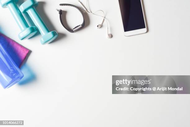 close-up of sports equipment on white table smart phone app, dumbbells, fitness tracker copy space - net sports equipment stock-fotos und bilder