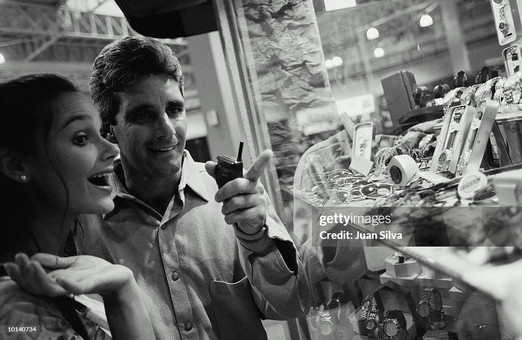 35-40 COUPLE LOOKING AT JEWELRY DISPLAY