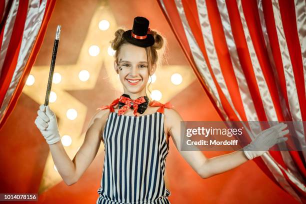 chica joven alegre jugando a mago circo performance - truco de magia fotografías e imágenes de stock