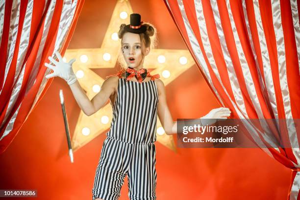 überrascht young girl illusionist sinkt zauberstab - zirkus kinder stock-fotos und bilder