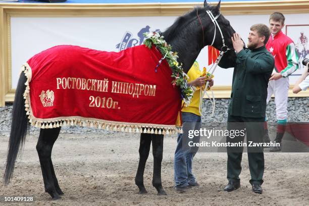 Chechen President Ramzan Kadyrov pets his horse Khorezm having watchede as it raced to victory in prestigious 2,400-meter President of the Russian...