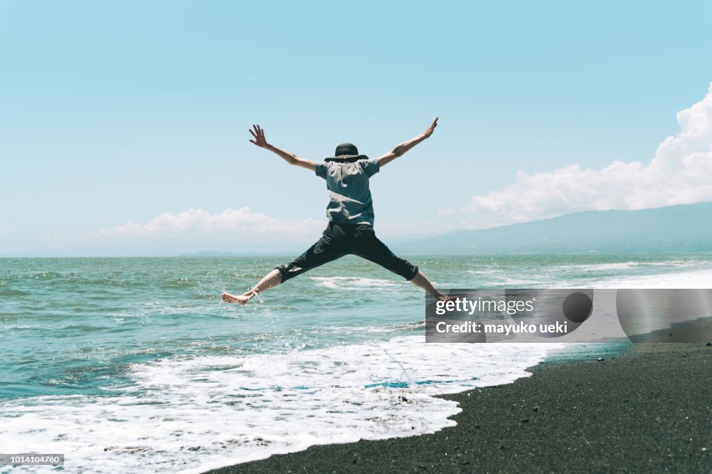 Una mujer saltando en la playa