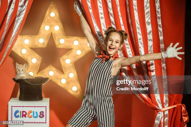 fröhliches mädchen prestidigitator mit kätzchen, das von hut erscheint - zirkus kinder stock-fotos und bilder