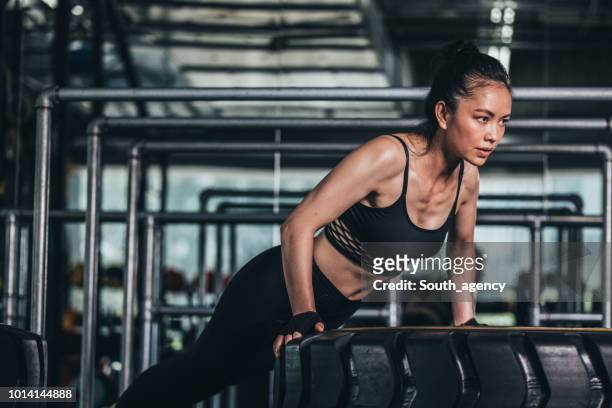 fit woman hartes training - asian female bodybuilder stock-fotos und bilder
