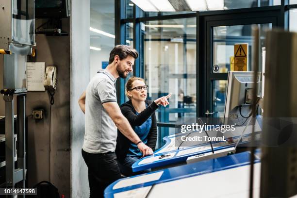 trabajadores de la fábrica opera maquinaria de impresión digital de gran - edificio industrial fotografías e imágenes de stock