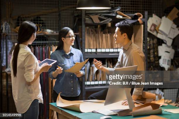 confident leather craftspeople working in studio - design studio woman chinese laptop fotografías e imágenes de stock
