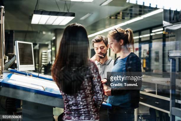 printing plant engineers working together at console - engineer stock pictures, royalty-free photos & images