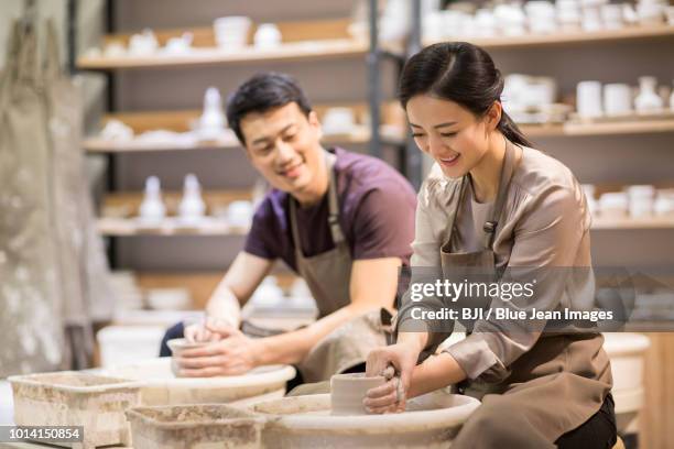 potter teaching young woman making pottery - pottery making stock pictures, royalty-free photos & images