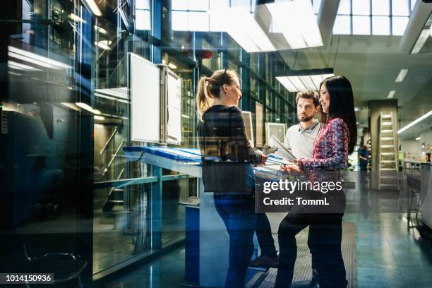 team van ingenieurs met discussie aan balie - drukkerij stockfoto's en -beelden