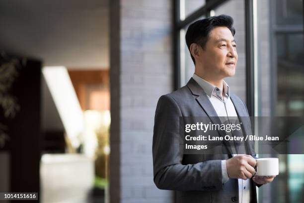 confident businessman drinking coffee - wealthy asian man stock pictures, royalty-free photos & images