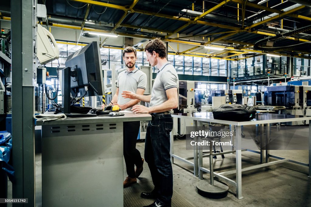 Dos ingenieros colaborando en consola