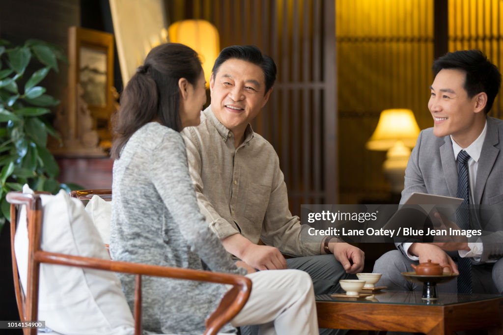 Confident financial consultant talking with mature couple