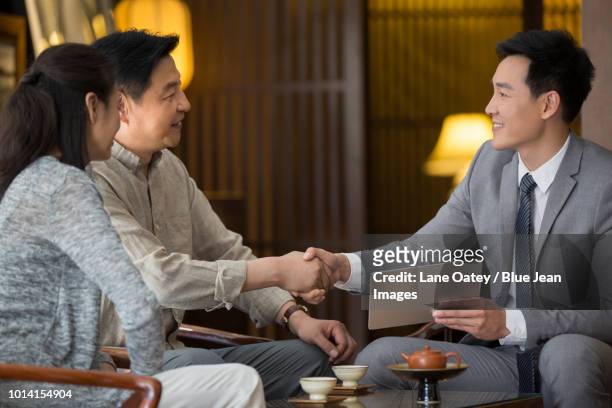 confident financial consultant shaking hands with mature couple - asian couple having hi tea stock pictures, royalty-free photos & images