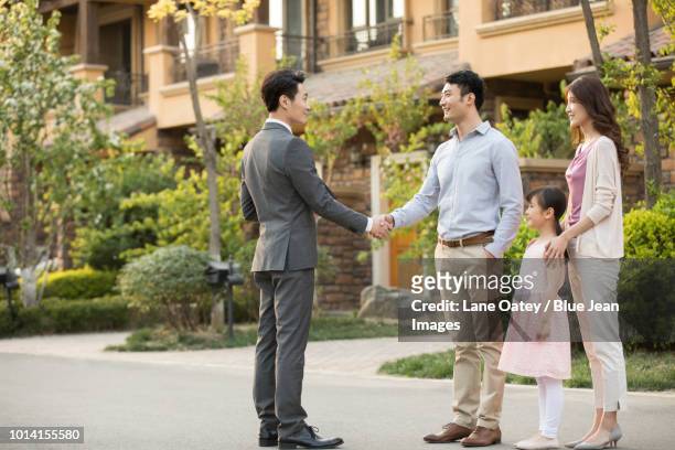 happy young family shaking hands with real estate agent - owners union agree to extend talks fotografías e imágenes de stock