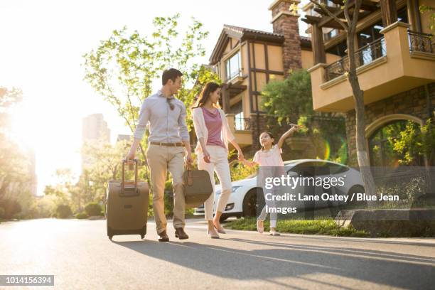 happy young family going for vacation - dreiviertel vorderansicht stock-fotos und bilder
