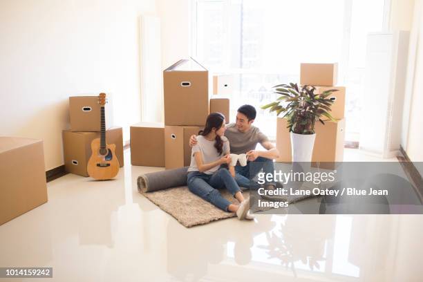 happy young couple moving to a new house - einzug gegenlicht stock-fotos und bilder