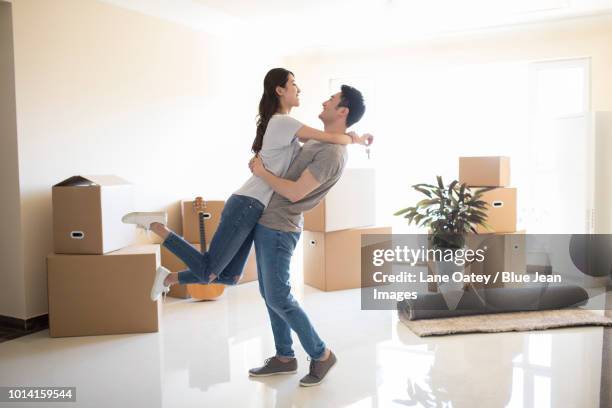 happy young couple moving to a new house - einzug gegenlicht stock-fotos und bilder