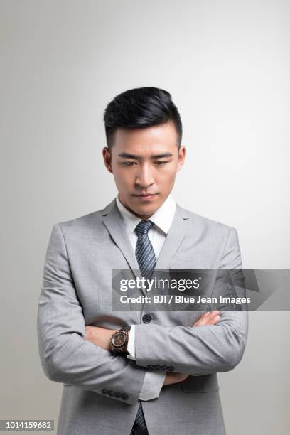 confident young businessman thinking - omlaag kijken stockfoto's en -beelden
