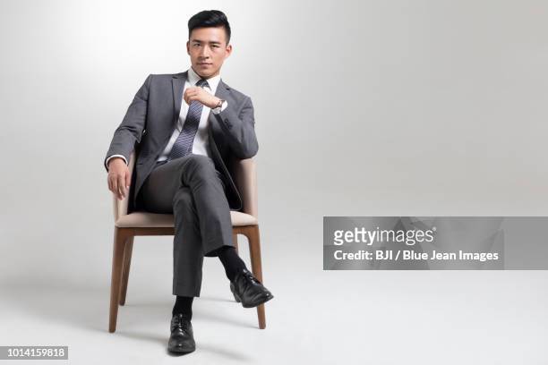 portrait of young businessman - legs crossed at knee stock pictures, royalty-free photos & images