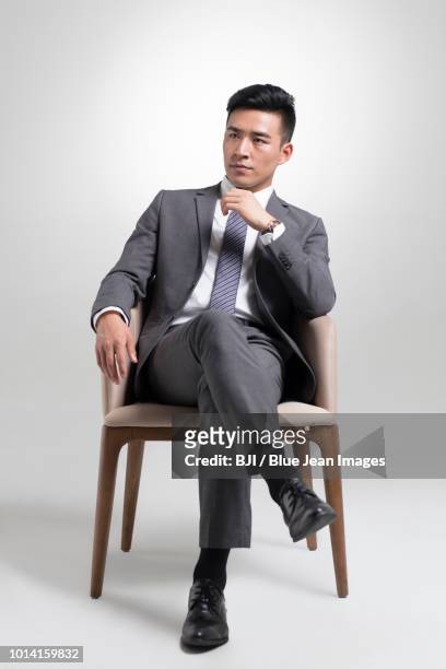 confident young businessman thinking - legs crossed at knee stock pictures, royalty-free photos & images