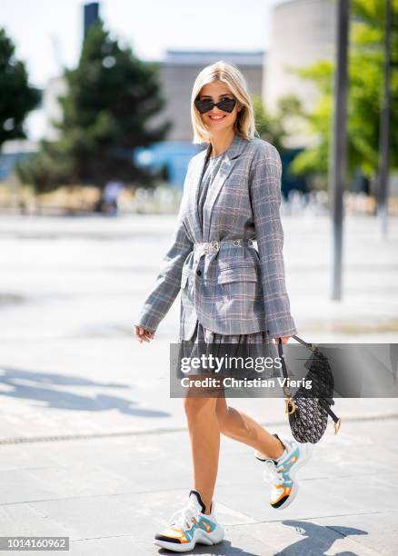 Xenia Adonts wearing Louis Vuitton sneakers, Dior saddle bag, grey checked belted jacket is seen outside Designers Remix during the Copenhagen...
