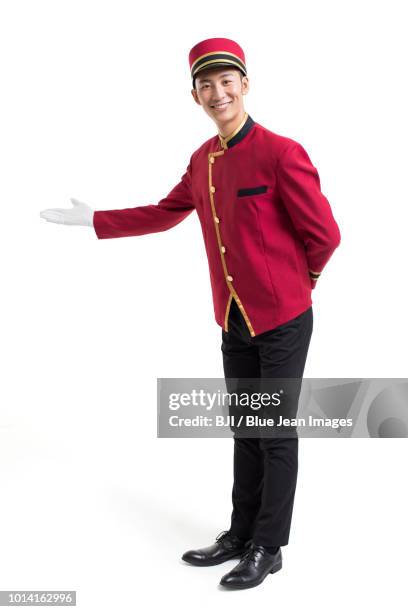 young bellboy greeting - bellhop stock pictures, royalty-free photos & images