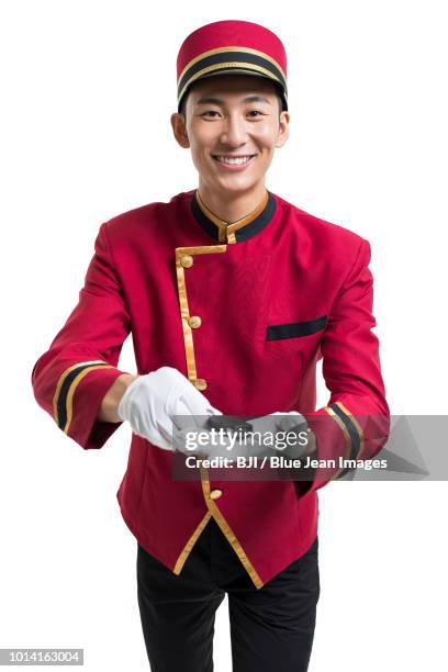 young bellboy holding a car key - bellhop stock pictures, royalty-free photos & images
