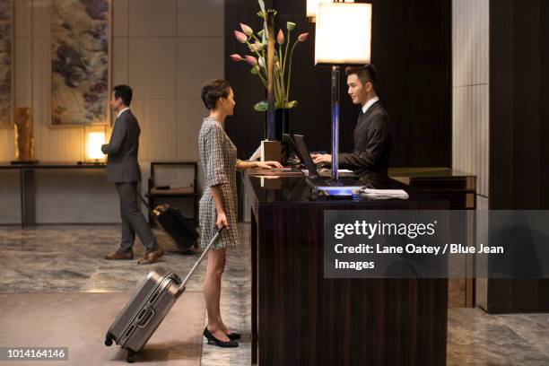 elegant woman checking into hotel - vip reception stock pictures, royalty-free photos & images