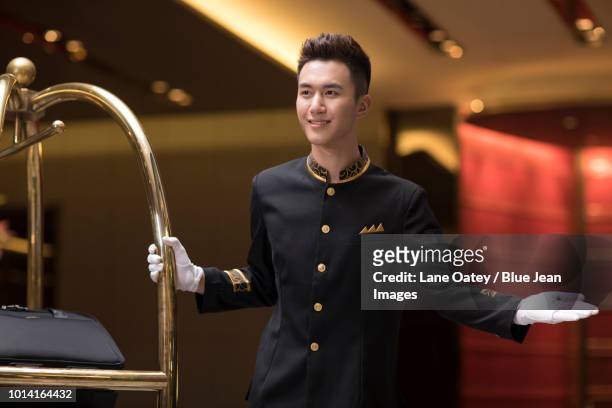 cheerful bell boy greeting - hotel bell stockfoto's en -beelden