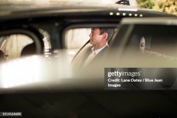 successful businessman sitting in car back seat - mann 40 bis 50 business auto stock-fotos und bilder