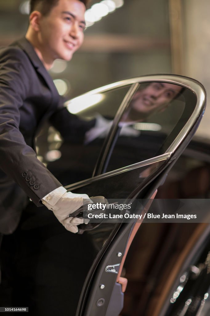 Chauffeur opening car door for passenger